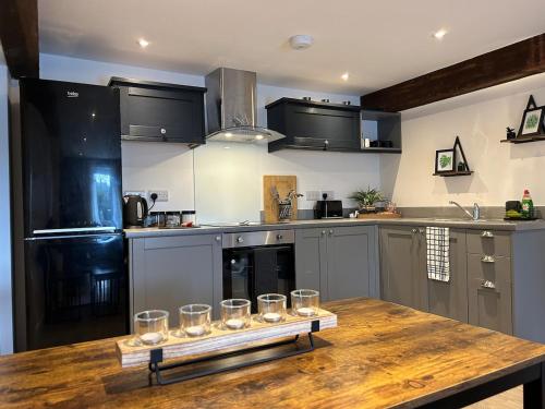 a kitchen with a wooden table with glasses on it at The Maltings - Contemporary 2 bedroom apartment with en-suite in Kirk Sandall