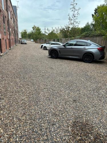 a row of cars parked on the side of a street at The Maltings - Contemporary 2 bedroom apartment with en-suite in Kirk Sandall