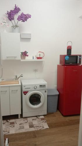 a kitchen with a washing machine and a red refrigerator at MONDELLO JUNO'S ROOMS in Mondello