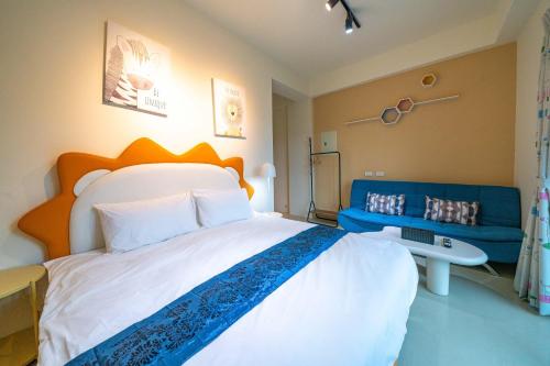 a bedroom with a large bed and a blue couch at 寵物友善-無門禁24小時進出-不想回家民宿-免費停車 in Chung-ho