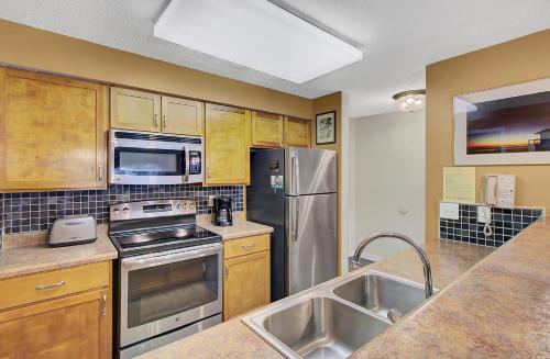 a kitchen with stainless steel appliances and wooden cabinets at Lagoon Villas 13 by Wild Dunes, with Amenities in Isle of Palms