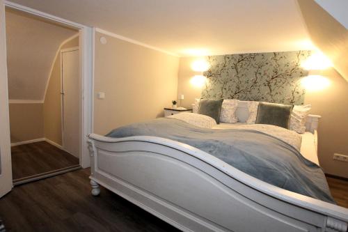a bedroom with a large white bed with a headboard at Ferienhaus Charlotte in Goslar