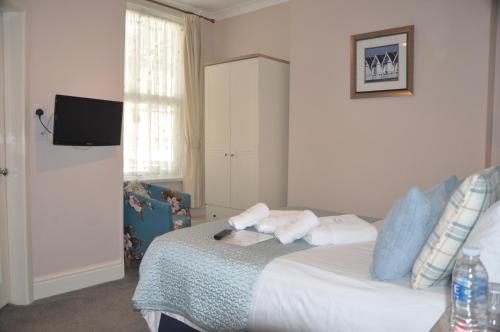 a bedroom with a bed with towels on it at Hotel Peppers in Torquay