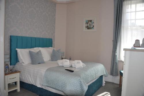 a bedroom with a bed with towels on it at Hotel Peppers in Torquay
