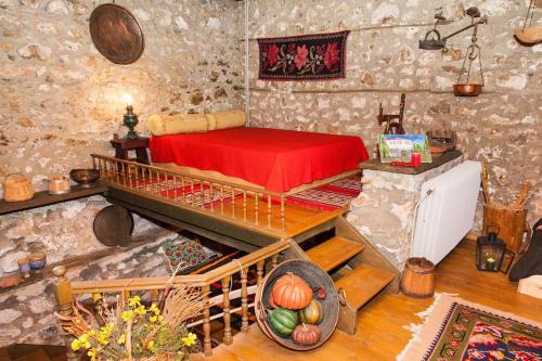 a room with a bed in a stone walled room at 260m2 Unique mountain house in Lilea Parnasos in Lílaia