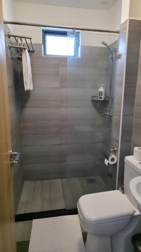 a bathroom with a shower with a toilet and a sink at Beautiful Studio apartment in Nairobi