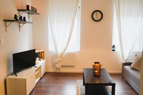 a living room with a couch and a clock on the wall at RM-1 - Joli 2 pièces tout équipé au 1er étage pour 1-3 pers in Mulhouse
