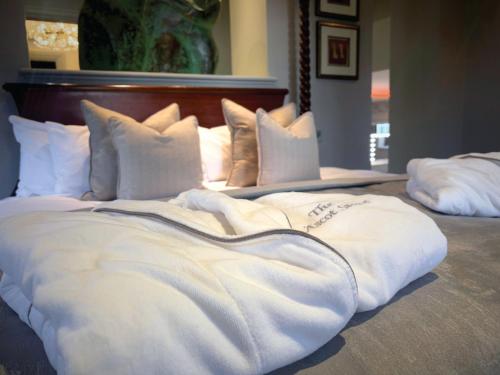 a large bed with white blankets and pillows on it at Western House Hotel At Ayr Racecourse in Ayr