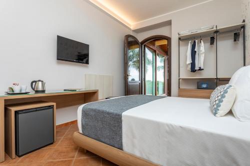 a bedroom with a bed and a tv at Feudogrande Bio Relais Hotel in Fiumefreddo di Sicilia