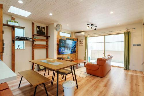 a living room with a table and a couch at USJ電車1分 最大12名 一戸建て貸切 無料駐車2台可 ファミリー 団体最適 WiFi完備 in Osaka