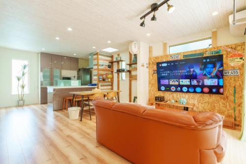 a living room with a couch and a large tv at USJ電車1分 最大12名 一戸建て貸切 無料駐車2台可 ファミリー 団体最適 WiFi完備 in Osaka