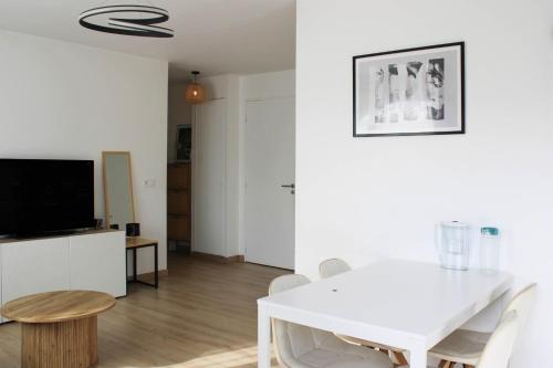 une salle à manger blanche avec une table et des chaises blanches dans l'établissement T3 apartment with Wifi near Paris, à Bobigny