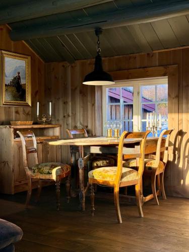 a dining room with a wooden table and chairs at Geilo - Charming cottage with a stunning view in Geilo