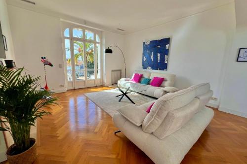 - un salon avec deux canapés blancs et des oreillers roses dans l'établissement Cannes Tassigny Stylish - 2 Bedroom Apartment Sleeps 4 Free Parking, à Cannes