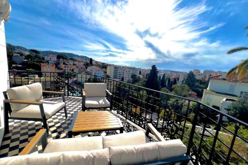 un balcon avec des chaises et une vue sur la ville dans l'établissement Cannes Tassigny Stylish - 2 Bedroom Apartment Sleeps 4 Free Parking, à Cannes