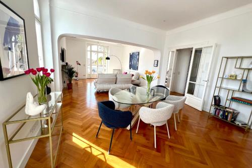 un salon avec une table en verre et des chaises dans l'établissement Cannes Tassigny Stylish - 2 Bedroom Apartment Sleeps 4 Free Parking, à Cannes