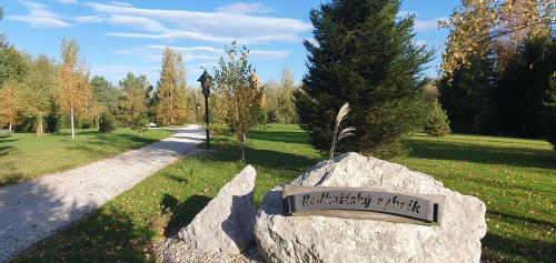 a sign on a rock in a park at Radhošťský rybník in Trojanovice