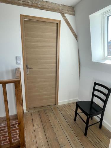 a wooden door in a room with a chair at L havre de paix in Avelin