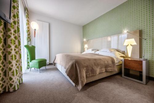 a bedroom with a bed and a green wall at Hotel Eden Roc - The Leading Hotels of the World in Ascona
