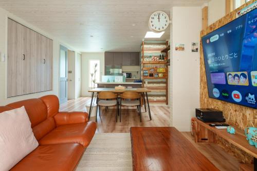 a living room with a couch and a dining room at USJ電車1分 最大12名 一戸建て貸切 無料駐車2台可 ファミリー 団体最適 WiFi完備 in Osaka
