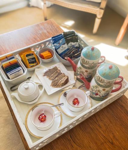 a tray with cups and dishes on a table at Newton Cottage in Porthcawl