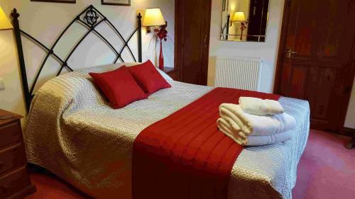 a bedroom with a bed with towels on it at OYO The Walnut Tree in West Camel
