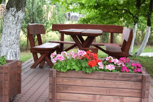 two benches and a table and flowers in a wooden box at Chata Skrzata in Kruszyn