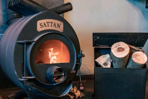 a wood fired oven with a fire in a box at Chata Margit - Margit-lak in Szalóc