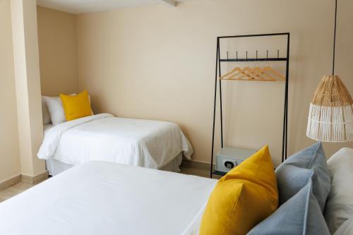 two beds in a room with yellow pillows at Magnolia Inn in Panama City