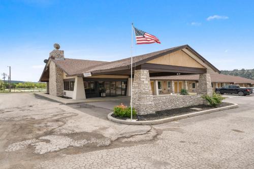 a building with an american flag in a parking lot at OYO Hotel Junction TX I-10 in Junction