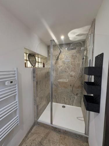une douche avec une porte vitrée dans une salle de bain dans l'établissement Le Cassiopée, à Ensuès-la-Redonne