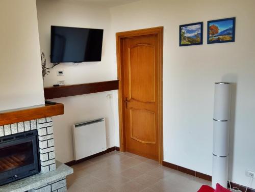 a room with a door and a television on the wall at Casa Margherita Top in Sorico