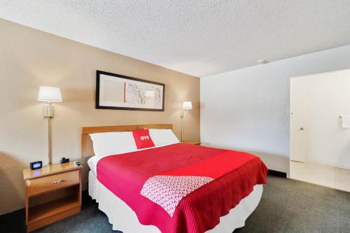 a hotel room with a large bed with a red blanket at OYO Hotel Junction TX I-10 in Junction