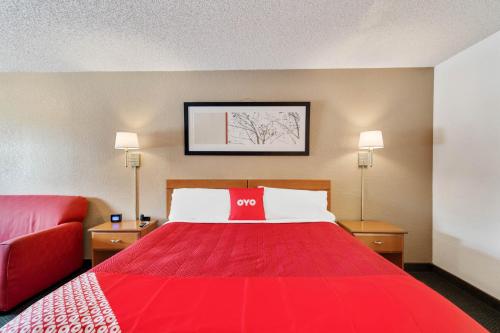 a hotel room with a red bed and a red couch at OYO Hotel Junction TX I-10 in Junction