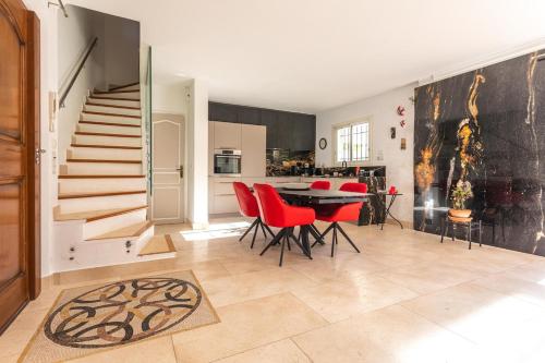 une cuisine et une salle à manger avec une table et des chaises rouges dans l'établissement Villa 6 Pers à 150m de la plage, à Saint-Raphaël