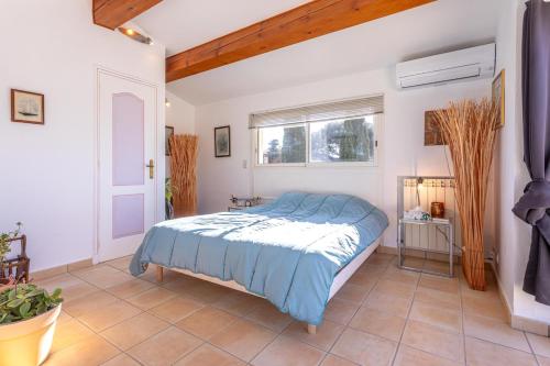 une chambre avec un lit avec une couette bleue dans l'établissement Villa 6 Pers à 150m de la plage, à Saint-Raphaël