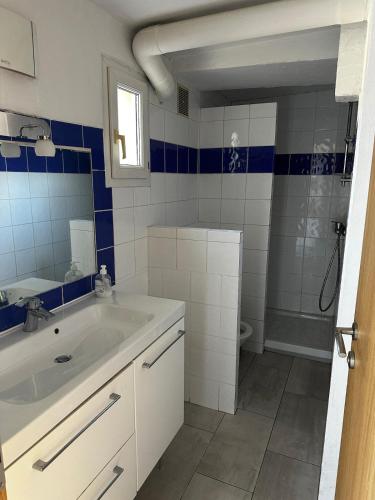 une salle de bain blanche avec un lavabo et une douche dans l'établissement Duplex 5 min de la mer, piscine, à Antibes