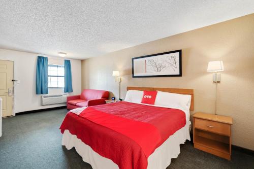 a hotel room with a red bed and a red chair at OYO Hotel Junction TX I-10 in Junction
