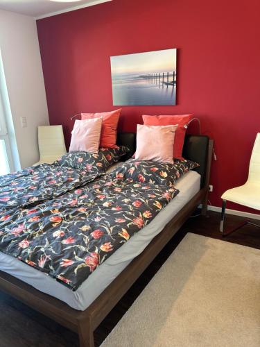 a bed in a room with a red wall at Hering in Scharbeutz