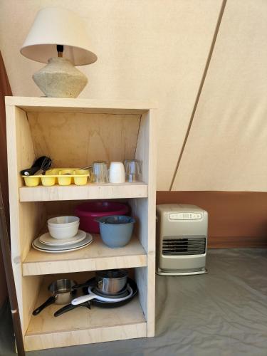 a toy cabinet with dishes and a printer at Hoeve Linnerveld Trekkerstent in Sint Odiliënberg