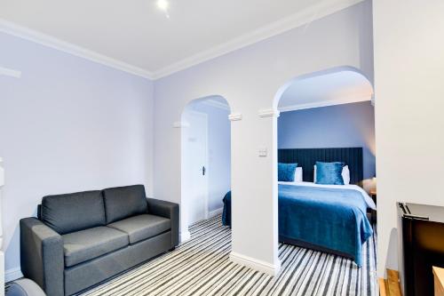a bedroom with a bed and a couch at Aston Court Derby City Centre by Belvilla in Derby