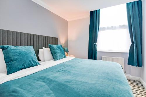 a bedroom with a large bed with blue pillows at Aston Court Derby City Centre by Belvilla in Derby