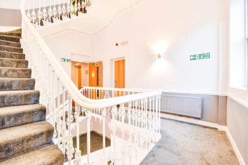 a white staircase with white railings in a house at Aston Court Derby City Centre by Belvilla in Derby