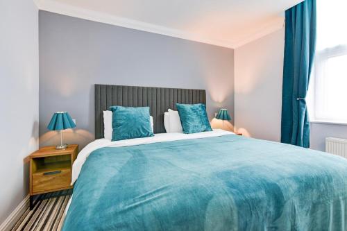 a bedroom with a large blue bed with blue curtains at Aston Court Derby City Centre by Belvilla in Derby