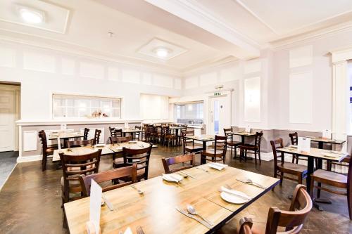 a dining room with wooden tables and chairs at Aston Court Derby City Centre by Belvilla in Derby