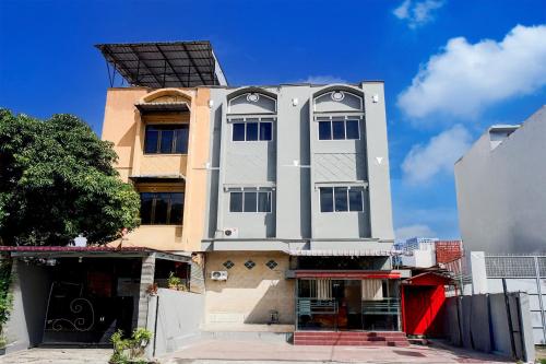 a tall white building with a lot of windows at Hotel O Medan City Center Near Plaza Medan Fair Formerly Waringin Residence in Medan