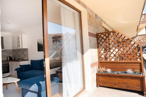 sala de estar con sofá azul y puerta corredera de cristal en Pirin Sense Amazing Studio - Spa - FREE Parking, en Bansko