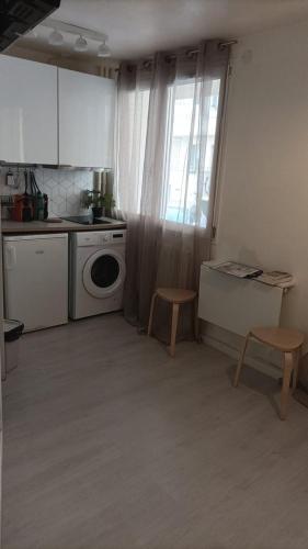 une cuisine avec une machine à laver et une fenêtre dans l'établissement Le Paul B - Yellow, à Lyon