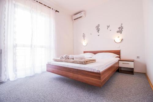 sypialnia z dużym łóżkiem z drewnianym zagłówkiem w obiekcie Pansion Maria w mieście Zadar