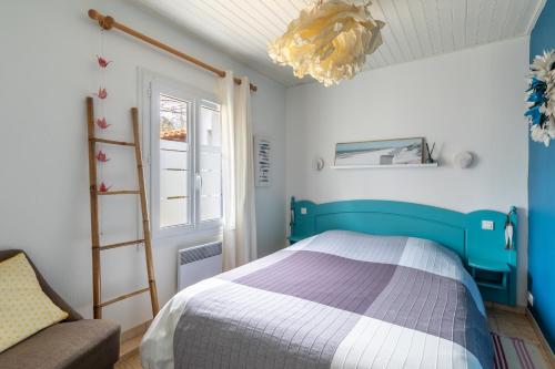 - une chambre avec un lit bleu et un canapé dans l'établissement Le Victoria - Proche de la Plage, à Saint-Jean-de-Monts